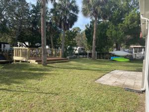 a yard with a deck and a green frisbee at ChassRiverVibes in Homosassa