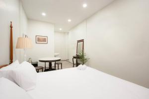 a white bedroom with a bed and a table at Hidden Dragon China Town MRT Dragon Temple in Samphanthawong