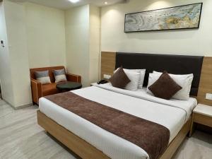 a hotel room with a large bed and a chair at HOTEL TOUCHWOOD in Visakhapatnam
