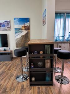 a room with two bar stools and a tv at MacchiabelliHome Centro Recco in Recco +14 photos