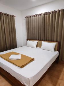 a bed in a room with curtains on it at Hotel Nova in Cochin