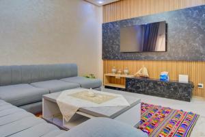 a living room with a couch and a tv at Golden Appartement Agadir in Agadir