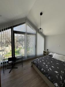 a bedroom with a bed and a large window at Tremythia Homes - Deluxe loft and 2-bed houses in Konia