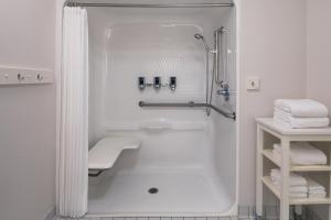 a white bathroom with a shower and a sink at Four Points Bentonville in Bentonville +17 photos