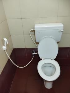 ein Badezimmer mit einem weißen WC mit einem Schlauch in der Unterkunft Shri Matha Chathra Residency in Kollūru