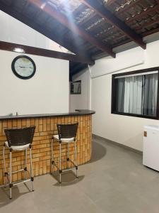 a bar with two chairs and a clock on a wall at Casa Sinop in Sinop