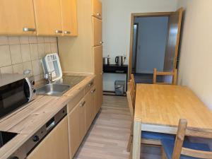 リヒテンシュタインにあるRuhige Unterkunft für 4 Personenのキッチン(シンク、テーブル、カウンター付)