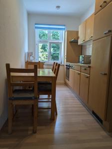 リヒテンシュタインにあるRuhige Unterkunft für 4 Personenのテーブルと椅子と窓のあるキッチン