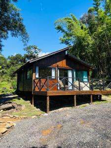 a small cabin with a porch on a gravel road at Fazenda Serramar Cabanas in Palhoça