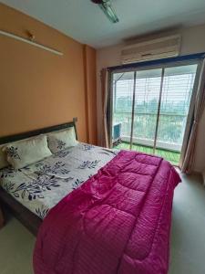 a bedroom with a large bed with a large window at Teju's Nest in Badlapur +19 photos