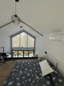 a bedroom with a bed and a large window at Tremythia Homes - Deluxe loft and 2-bed houses in Konia