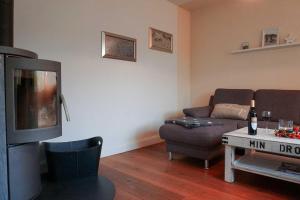 a living room with a couch and a tv at Ferienhaus-Min-Drom in Sankt Peter-Ording