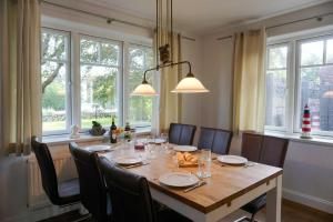 a dining room table with chairs and a large window at Ferienhaus-Min-Drom in Sankt Peter-Ording