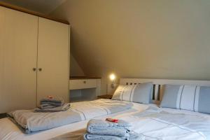 a bedroom with a large white bed with towels on it at Ferienhaus-Min-Drom in Sankt Peter-Ording