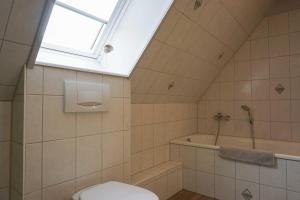 a bathroom with a toilet and a tub and a window at Ferienhaus-Min-Drom in Sankt Peter-Ording +19 photos