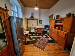 a kitchen with a refrigerator and a checkered floor at Das alte Herrenhaus auf dem Bio-Bauernhof in Kevelaer
