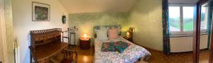 a bedroom with a bed and a piano at Gîte Des Prés Berthe in Le Clerjus