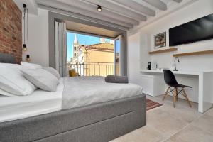 Schlafzimmer mit einem Bett, einem Schreibtisch und einem Fenster in der Unterkunft Apartments & Rooms Mareta Exclusive in Zadar