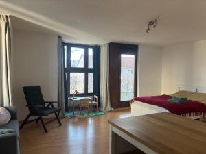 慕尼黑Studio-Apartment的客厅配有床、桌子和窗户