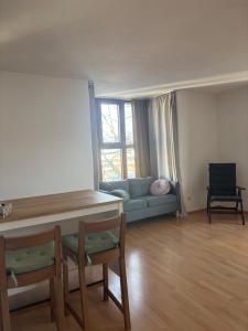 慕尼黑Studio-Apartment的带沙发、桌子和椅子的客厅