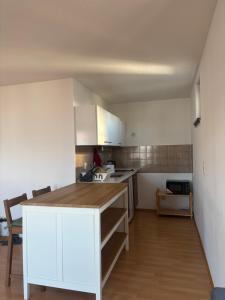 慕尼黑Studio-Apartment的配有白色橱柜和木质台面的厨房 更多8张照片