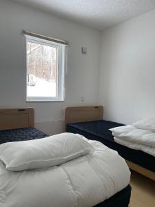 Postel nebo postele na pokoji v ubytování Niseko Yu Villa D