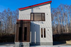 a small white building with a large window on it at Niseko Yu Villa D in Niseko