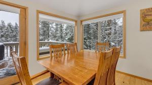 comedor con mesa de madera y 2 ventanas en Vine Maple - Unit 30, en Sunriver