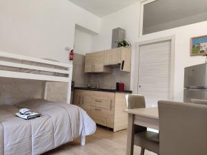 a bedroom with a bed and a desk and a kitchen at Villa don peppe in Selva di Fasano