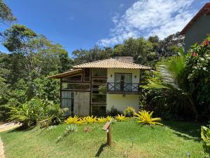 a small house in the middle of a yard at Casa Recanto das arvores in Itacaré