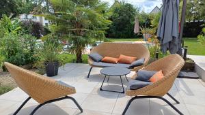 a patio with wicker chairs and a table on a patio at Villa avec piscine en Alsace in Eschau