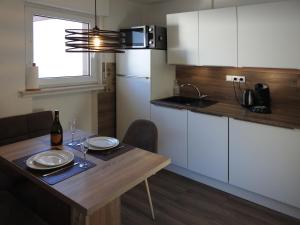 una pequeña cocina con mesa de madera y comedor en FeWo Pieck mit Parkplatz und privater Garage, en Winterberg 40 fotos más