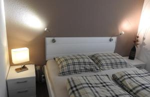 1 dormitorio con 1 cama con 2 almohadas a cuadros en FeWo Pieck mit Parkplatz und privater Garage, en Winterberg