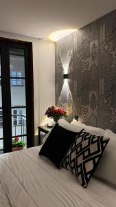 a bedroom with a white bed and a wall with at Casa Laura Hotel & Suites in Cuenca