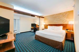 a hotel room with a bed and a flat screen tv at Fairfield Inn & Suites by Marriott Greenville Simpsonville in Simpsonville