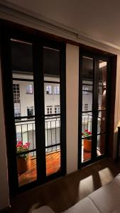 a room with three windows looking out at a balcony at Casa Laura Hotel & Suites in Cuenca