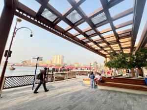 a group of people walking on a boardwalk at Aygro Hotel in Dubai