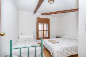 Un dormitorio con dos camas y una ventana. en BaruHaus VillaHermosa, en Villamañán
