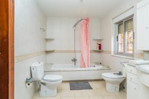 un baño con inodoro y bañera en BaruHaus VillaHermosa, en Villamañán