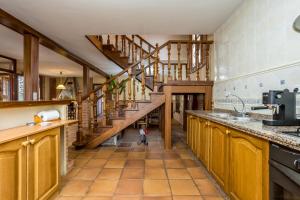Una gran cocina con suelos de madera y escaleras de madera. en BaruHaus VillaHermosa, en Villamañán