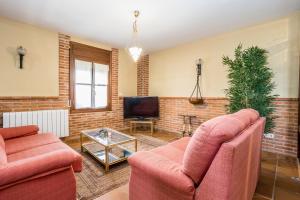 Una sala de estar con dos sofás y un televisor. en BaruHaus VillaHermosa, en Villamañán