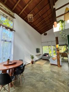 a living room with a table and chairs at Casa Recanto das arvores in Itacaré
