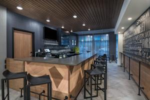 a bar in a restaurant with black walls and black stools at Fairfield Inn and Suites by Marriott St Louis Downtown in Saint Louis