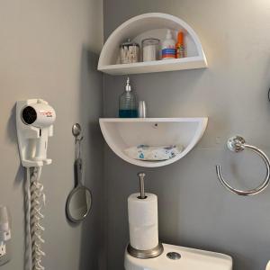 Baño con aseo y estante encima en Suite Life at Chez Mercedes, en Miami 20 fotos más