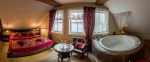 a bedroom with a large bed and a tub at Argo Trakai in Trakai