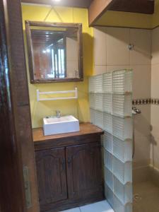 een badkamer met een wastafel en een spiegel bij Cabaña El Banbi in La Coronilla