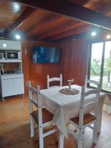 een eetkamer met een witte tafel en stoelen bij Cabaña El Banbi in La Coronilla