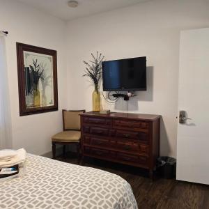 1 dormitorio con cama y vestidor con TV en Suite Life at Chez Mercedes, en Miami