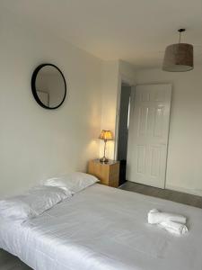 a bedroom with a white bed and a mirror at Northgate House in Chester