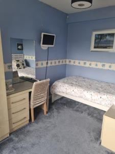 a bedroom with a bed and a desk and a chair at The Sands Hotel in Paignton